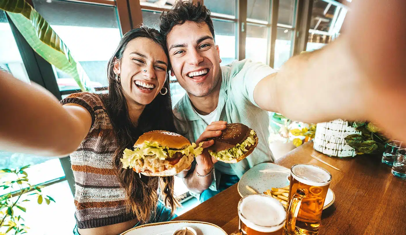 Young couple taking a selfie with their burgers.