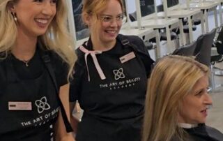 art-of-beauty-academy-pavilions-talking-stick-scottsdale Instructors in The Art of Beauty Academy aprons working with a client in the salon studio at The Pavilions at Talking Stick in Scottsdale