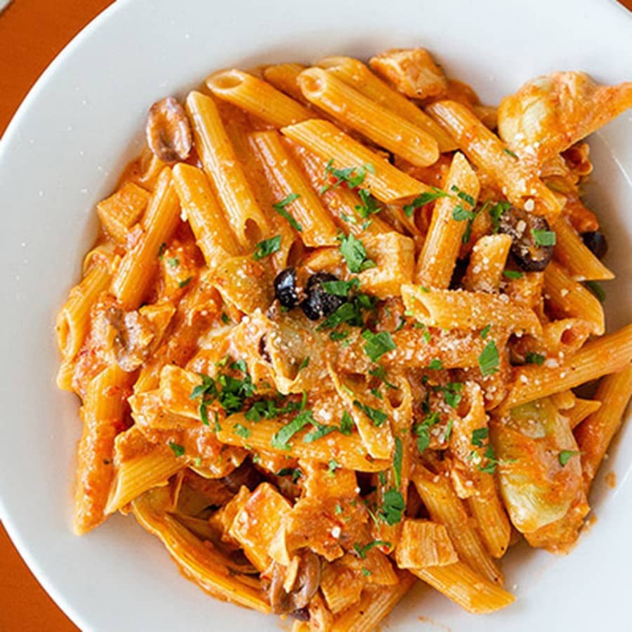 A bowl of penne pasta in creamy tomato sauce with mushrooms, olives and artichokes at Babbo Italian Eatery in Scottsdale